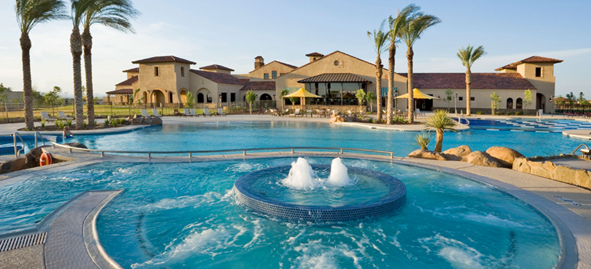 Resort-style Sun City clubhouse and pool with fountains and palm trees in the Arizona West Valley